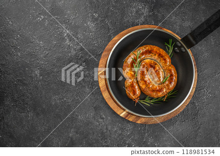 Snail sausage, Roasted sausage in pan on a dark background. top view. copy space for text 118981534