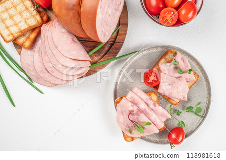Plate of tasty sandwiches with boiled sausage and tomato on white table Plate of tasty sandwiches with boiled sausage and tomato on white table 118981618