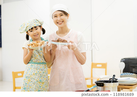 Mother and daughter cooking in aprons 118981689