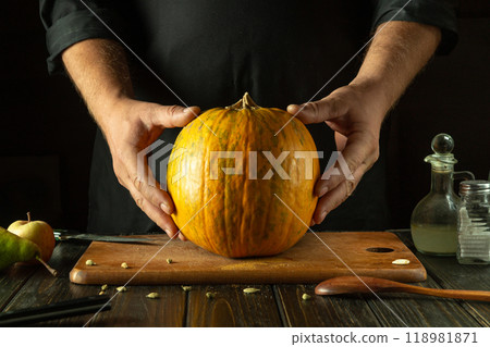 A large pumpkin on the kitchen counter before cooking by a chef. The concept of a vegetable diet or cooking a national dish 118981871
