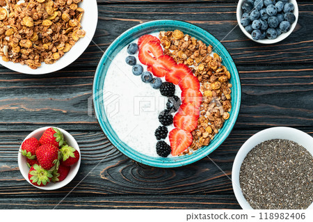 Healthy breakfast . Yogurt with berries ( strawberry , raspberry , blueberry , blackberry ) , granola and chia seeds . Top view Healthy breakfast . Yogurt with berries ( strawberry , raspberry , blueberry , blackberry ) , granola and chia seeds . Top view 118982406