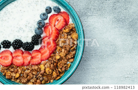 Healthy breakfast . Yogurt with berries ( strawberry , raspberry , blueberry , blackberry ) , granola and chia seeds . Top view 118982413