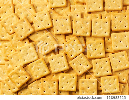 Square crackers background, crispy and crunchy square shape crackers, taken from above, close up. Square crackers background, crispy and crunchy square shape crackers, taken from above, close up. 118982513
