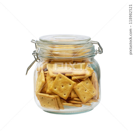 Salted crackers square shape in a clear glass jar, isolated on white background. Glass jar with square crackers. 118982521