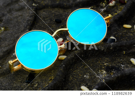 Vintage cool gold sunglasses with blue lenses on dark rusty iron Vintage cool gold sunglasses with blue lenses on dark rusty iron 118982639
