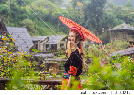 A female tourist dressed in the traditional dress of the inhabitants of the Vietnamese mountains, the Hmong. Woman in Sapa in the fog, Northwest Vietnam. Vietnam travel concept. UNESCO heritage A female tourist dressed in the traditional dress of the inhabitants of the Vietnamese mountains, the Hmong. Woman in Sapa in the fog, Northwest Vietnam. Vietnam travel concept. UNESCO heritage 118983212