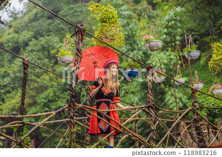 A female tourist dressed in the traditional dress of the inhabitants of the Vietnamese mountains, the Hmong. Woman in Sapa in the fog, Northwest Vietnam. Vietnam travel concept. UNESCO heritage A female tourist dressed in the traditional dress of the inhabitants of the Vietnamese mountains, the Hmong. Woman in Sapa in the fog, Northwest Vietnam. Vietnam travel concept. UNESCO heritage 118983216