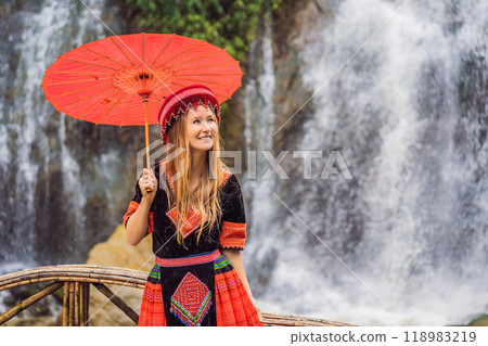 A female tourist dressed in the traditional dress of the inhabitants of the Vietnamese mountains, the Hmong. Woman in Sapa in the fog, Northwest Vietnam. Vietnam travel concept. UNESCO heritage A female tourist dressed in the traditional dress of the inhabitants of the Vietnamese mountains, the Hmong. Woman in Sapa in the fog, Northwest Vietnam. Vietnam travel concept. UNESCO heritage 118983219