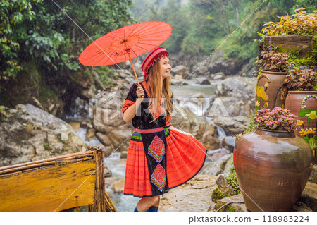 A female tourist dressed in the traditional dress of the inhabitants of the Vietnamese mountains, the Hmong. Woman in Sapa in the fog, Northwest Vietnam. Vietnam travel concept. UNESCO heritage 118983224