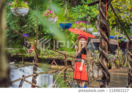 A female tourist dressed in the traditional dress of the inhabitants of the Vietnamese mountains, the Hmong. Woman in Sapa in the fog, Northwest Vietnam. Vietnam travel concept. UNESCO heritage A female tourist dressed in the traditional dress of the inhabitants of the Vietnamese mountains, the Hmong. Woman in Sapa in the fog, Northwest Vietnam. Vietnam travel concept. UNESCO heritage 118983227