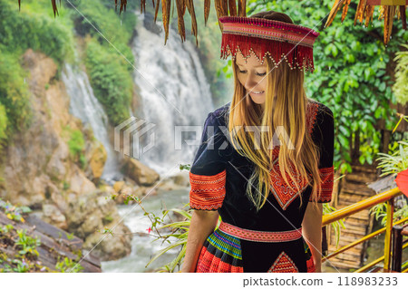 A female tourist dressed in the traditional dress of the inhabitants of the Vietnamese mountains, the Hmong. Woman in Sapa in the fog, Northwest Vietnam. Vietnam travel concept. UNESCO heritage A female tourist dressed in the traditional dress of the inhabitants of the Vietnamese mountains, the Hmong. Woman in Sapa in the fog, Northwest Vietnam. Vietnam travel concept. UNESCO heritage 118983233