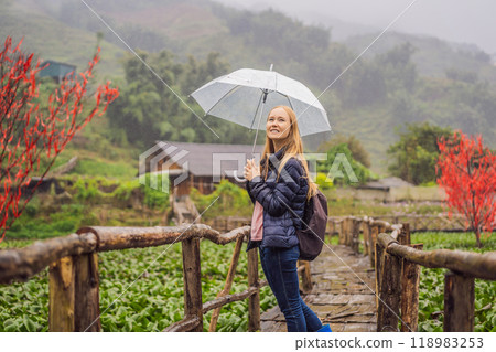 Woman tourist with umbrella in Sapa in the fog, Northwest Vietnam. Vietnam travel concept. UNESCO heritage. Vietnam opens to tourism after quarantine Coronovirus COVID 19 118983253
