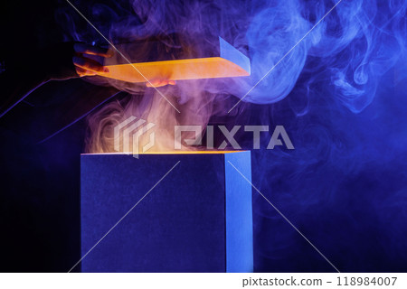 Man opens magic box with surprise on dark background, mystical box, surprise, halloween, monster box 118984007