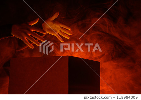 Man opens magic box with surprise on dark background, mystical box, surprise, halloween, monster box Man opens magic box with surprise on dark background, mystical box, surprise, halloween, monster box 118984009