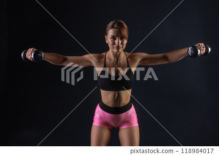 sporty girl doing exercises with dumbbells on black background, sport concept, healthy and beautiful body sporty girl doing exercises with dumbbells on black background, sport concept, healthy and beautiful body 118984017