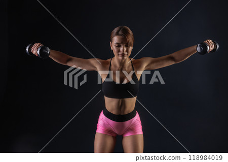 sporty girl doing exercises with dumbbells on black background, sport concept, healthy and beautiful body 118984019