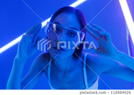 Concept of futuristic virtual reality technology or entertainment system. A woman lit up on the HUD interface Concept of futuristic virtual reality technology or entertainment system. A woman lit up on the HUD interface 118984026