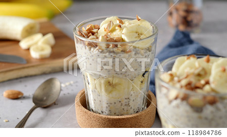 Two bowls of overnight oats topped with banana slices and almonds 118984786