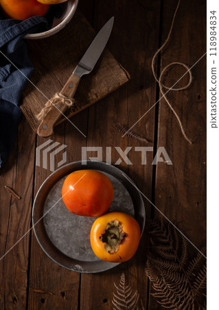 Rustic still life of persimmons on a metal plate Rustic still life of persimmons on a metal plate 118984834