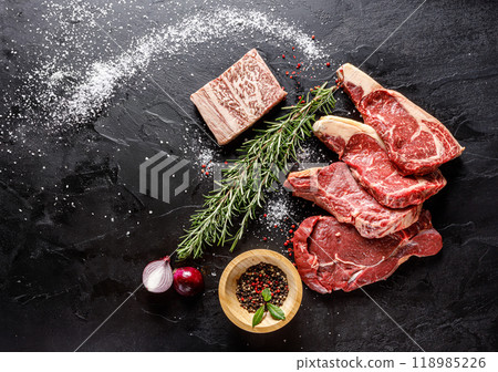 A curated selection of fresh meat with aromatic herbs and spices for gourmet cooking 118985226