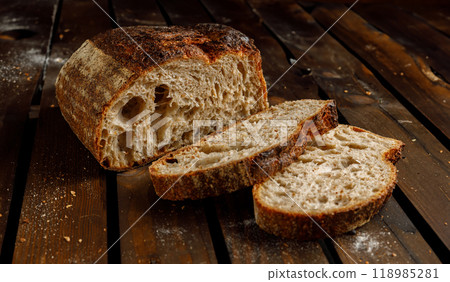 Freshly Baked Artisan Bread Beautifully Displayed on a Rustic Wooden Table Surface 118985281