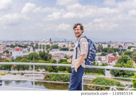 Male tourist in front of the panoramic view of Puebla city, Mexico. Travel, cultural exploration, and scenic landscape concept Male tourist in front of the panoramic view of Puebla city, Mexico. Travel, cultural exploration, and scenic landscape concept 118985534