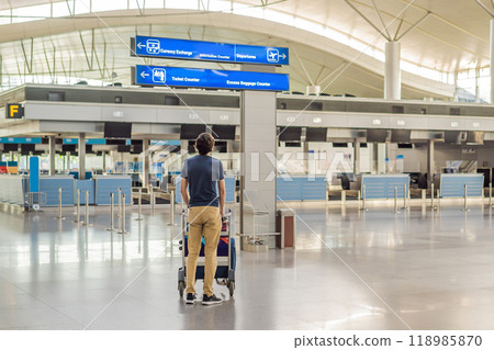 Man in mask at empty airport at check in in coronavirus quarantine isolation, returning home, flight cancellation, pandemic infection worldwide spread, travel restrictions and border shutdown Man in mask at empty airport at check in in coronavirus quarantine isolation, returning home, flight cancellation, pandemic infection worldwide spread, travel restrictions and border shutdown 118985870