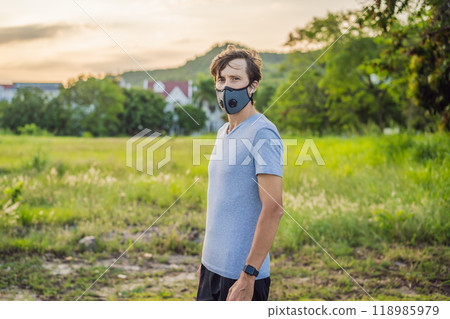 Runner wearing medical mask, Coronavirus pandemic Covid-19. Sport, Active life in quarantine surgical sterilizing face mask protection. Outdoor run on athletics track in Corona Outbreak 118985979