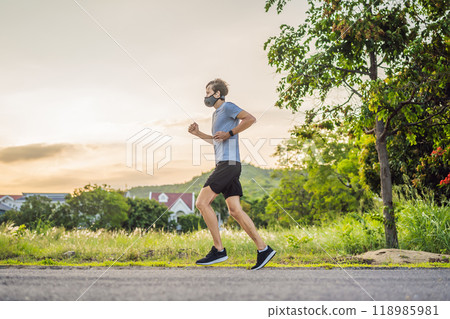 Runner wearing medical mask, Coronavirus pandemic Covid-19. Sport, Active life in quarantine surgical sterilizing face mask protection. Outdoor run on athletics track in Corona Outbreak 118985981