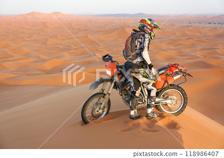 Man riding a motorbike through the desert 118986407