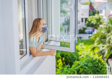 Extremly tired woman looking out the window, home alone. self-isolation at home, quarantine due to pandemic COVID 19. Mental health problems in self-isolation at home, quarantine, isolation, stay at 118986881