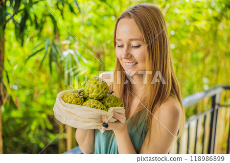 Cherimoya in a reusable bag in female hands. Zero waste concept, plastic free concept. Healthy clean eating diet and detox. Summer fruits 118986899