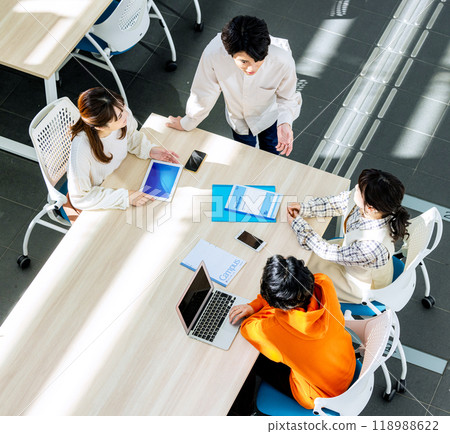 Male and female college students having a meeting in a classroom Male and female college students having a meeting in a classroom 118988622