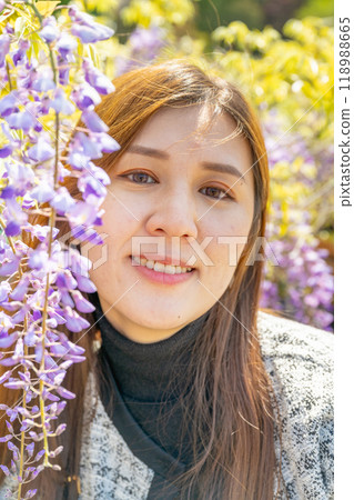 日本東京 — 2024年4月15日：女孩和紫藤花一起合照。 118988665