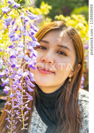 日本東京 — 2024年4月15日：女孩和紫藤花一起合照。 118988669