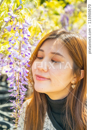日本東京 — 2024年4月15日：女孩和紫藤花一起合照。 118988670