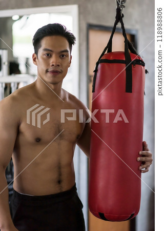 Asian young man portrait  with punchbag boxing bag in sport gym club 118988806