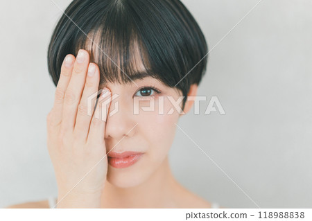 A woman looking at one eye 118988838