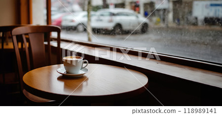 面向巴黎某條街道的一家擁有大玻璃窗的咖啡店。桌上有新鮮的歐蕾咖啡 面向巴黎某條街道的一家擁有大玻璃窗的咖啡店。桌上有新鮮的歐蕾咖啡 118989141