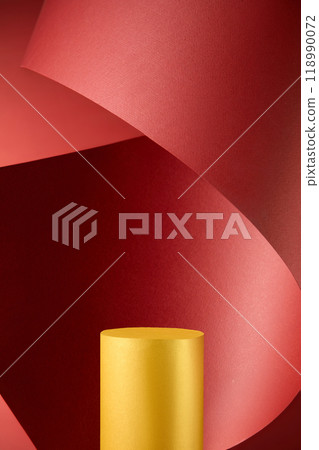 A single golden cylinder podium is arranged on a red paper backdrop, surrounded by a sweeping curve, creating a dynamic and rich setting for the product display, complemented by a subtle sheen. 118990072