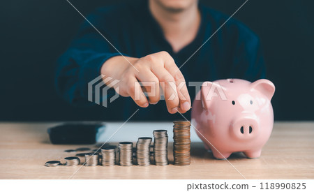 Businessman stacking coins and piggy bank, Money saving and investment growth and Business development concept. Businessman stacking coins and piggy bank, Money saving and investment growth and Business development concept. 118990825