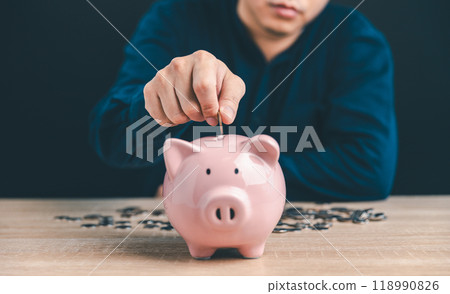 Man put money coin into pink piggy bank for saving money wealth, The concept of saving money or investment. Man put money coin into pink piggy bank for saving money wealth, The concept of saving money or investment. 118990826