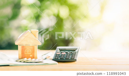 Close up house's model on notebook with calculator, coin and pen on table for Prepare planning of home loan mortgage refinance or retention interest rates, business and financial concept. investment. Close up house's model on notebook with calculator, coin and pen on table for Prepare planning of home loan mortgage refinance or retention interest rates, business and financial concept. investment. 118991043