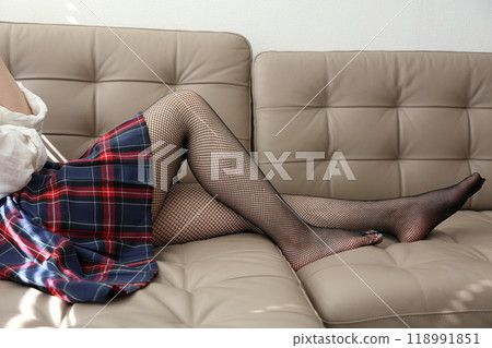穿著黑色漁網襪和迷你裙的女人的美腿 118991851