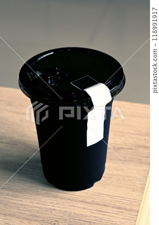 Black plastic glass on a wooden table Black plastic glass on a wooden table 118991917