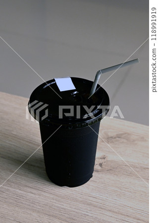 Black plastic glass on a wooden table Black plastic glass on a wooden table 118991919