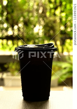 Black plastic glass on a wooden table Black plastic glass on a wooden table 118991921