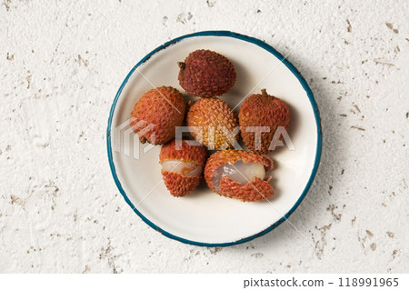 Tropical lychee berries on a metal vintage plate on a light background 118991965