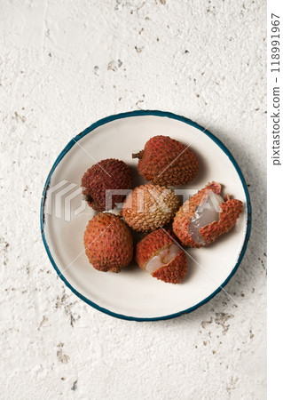 Lychee berries on a metal vintage plate on a light background Lychee berries on a metal vintage plate on a light background 118991967