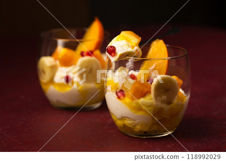 dessert with fruits in transparent glasses on a burgundy background dessert with fruits in transparent glasses on a burgundy background 118992029